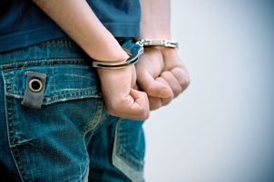 Man in handcuffs  - Michigan Aggravated Assault Attorney